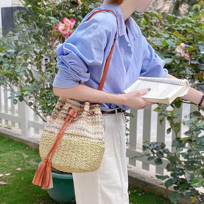 Model styling the natural straw bag in an outdoor garden setting.