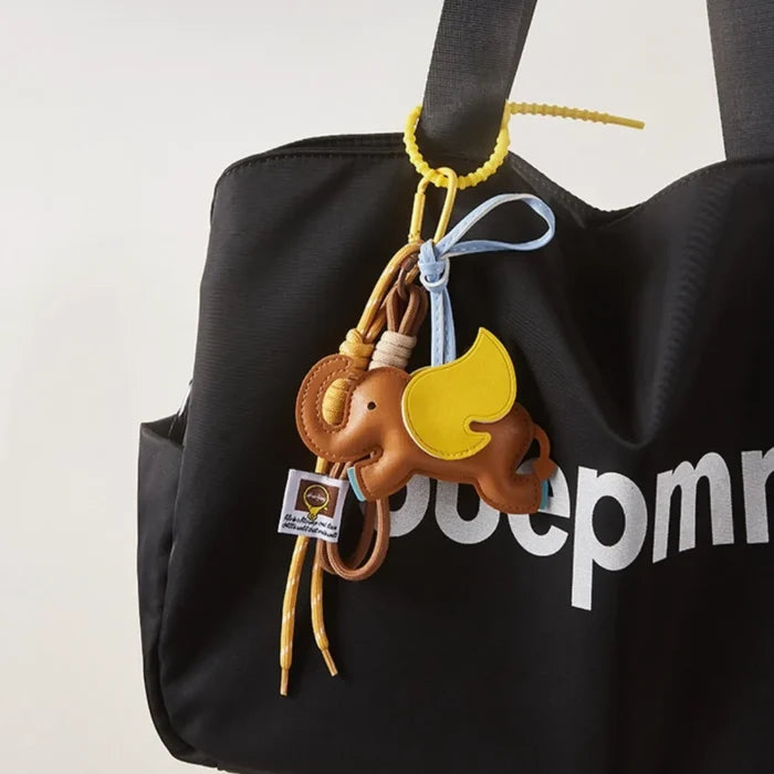 Dumbo Bag Charm hanging on a black tote bag, easy for gifting and photo-ready styling.