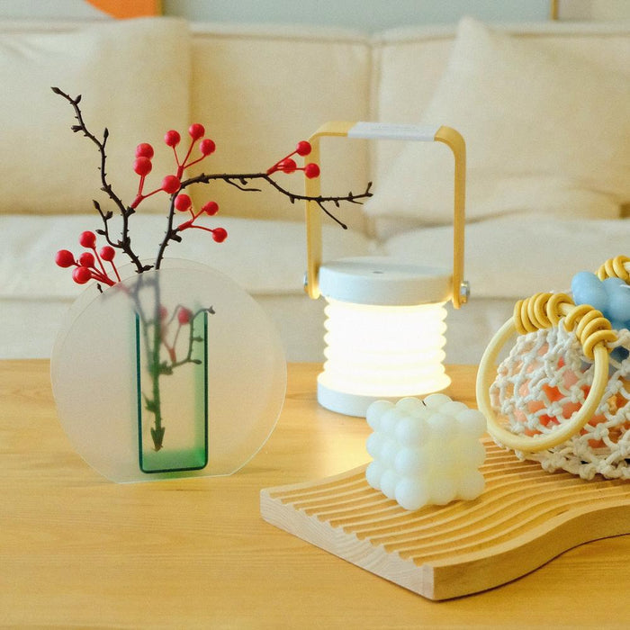 Lifestyle view of Green Frosted Vase with lamp and wooden tray beside.