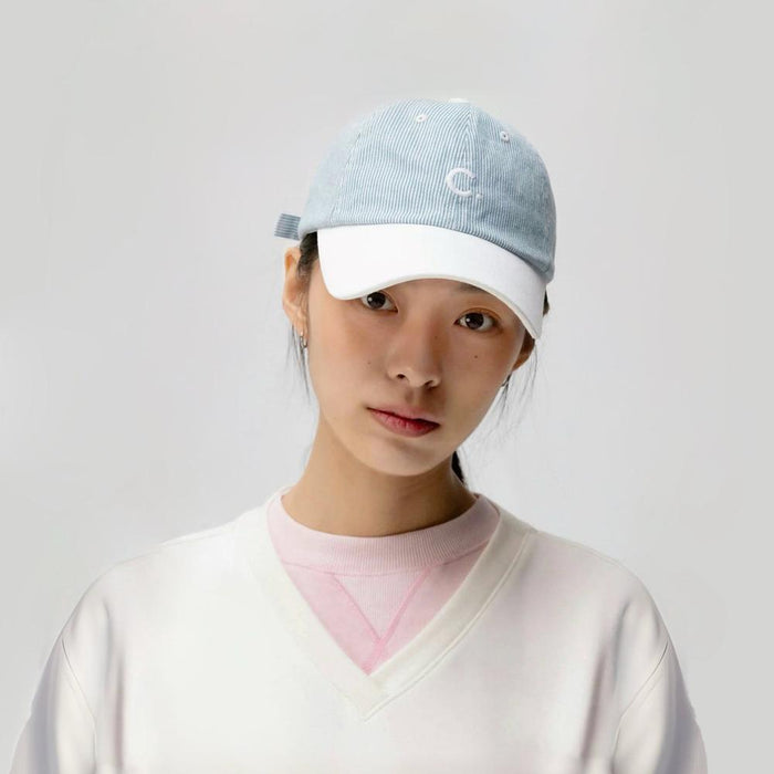 Model wearing light blue Mash Up Stripe C Cap, showcasing eclectic striped patterns on lightweight cotton material.