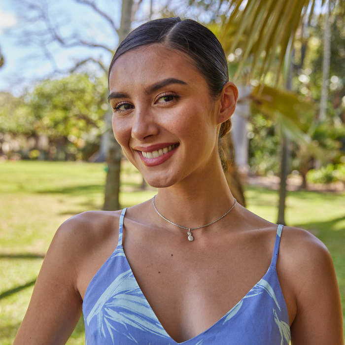 Woman smiling in a park wearing a Pineapple Charm/Pendant in Sterling Silver