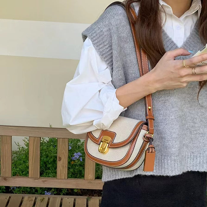 Close-up of the saddle bag worn over the shoulder; highlighting the adjustable strap and compact architecture.