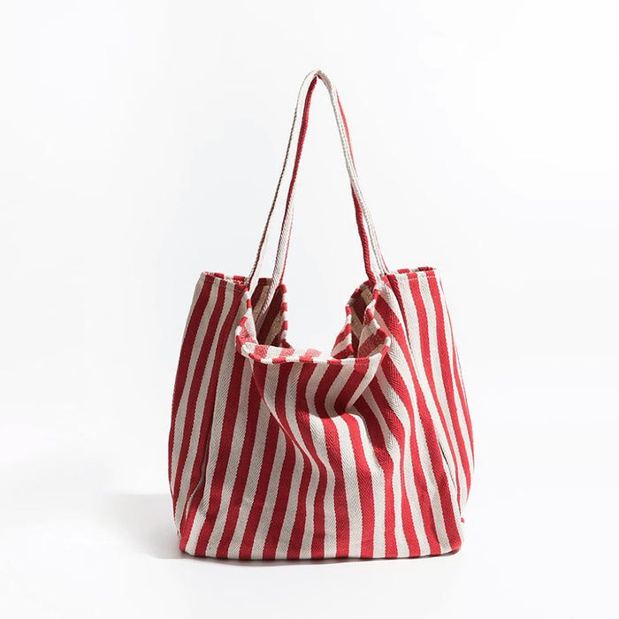 Front view of red and white striped canvas tote; vibrant pop of color perfect for holiday shopping and festive outings.