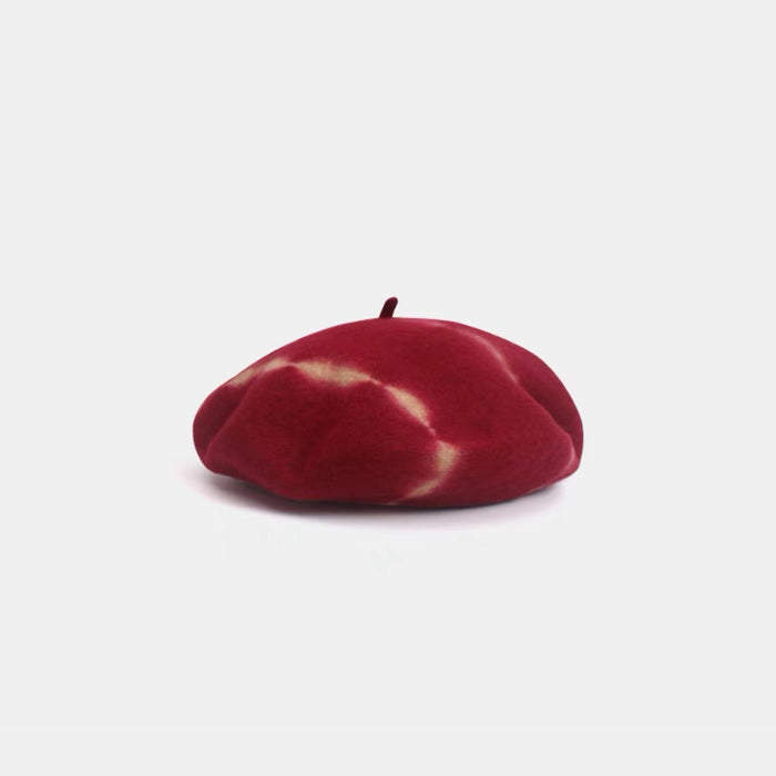 Red and white tie-dye wool beret displayed on a white background.