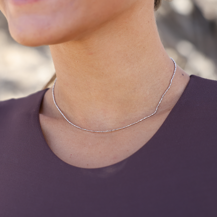 Close up of a person wearing 1.0mm Ball Bar Chain in Sterling Silver
