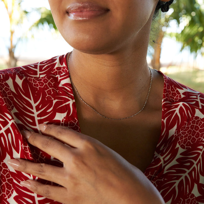 Close up of a person wearing 1.0mm Ball Bar Chain in Sterling Silver in a park