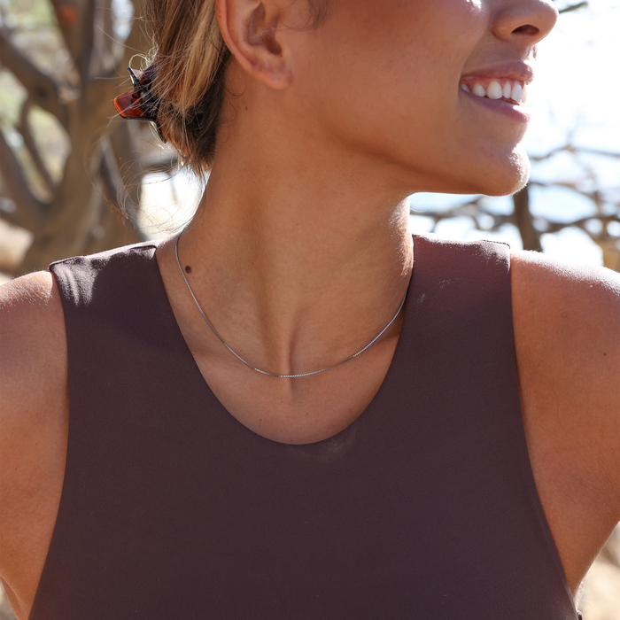 Close-up of a person wearing a 1.0mm box chain outdoors