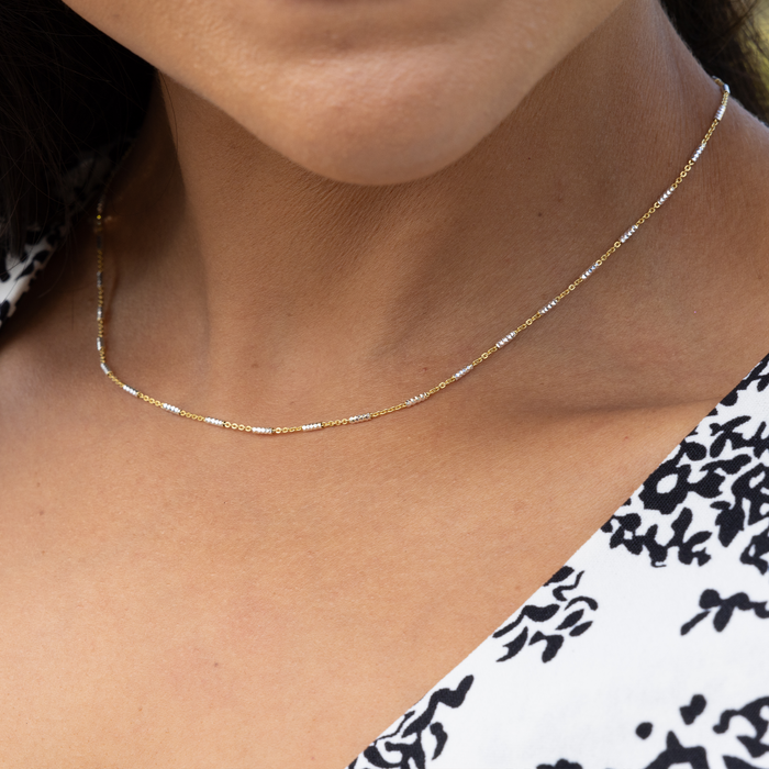Close up of 1.0mm Tube Chain in Yellow Gold and Sterling Silver on a womanʻs neck