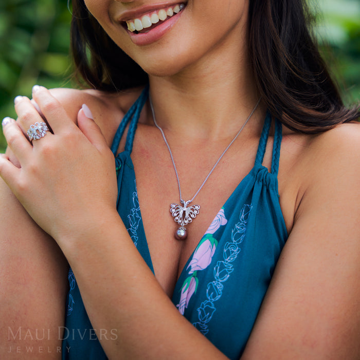 Woman in a park wearing a blue dress and a 1.2mm Round Box Chain in Sterling Silver with butterfly pendant