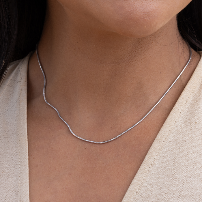 Close up of 1.4mm Snake Chain in Sterling Silver on a womanʻs neckline