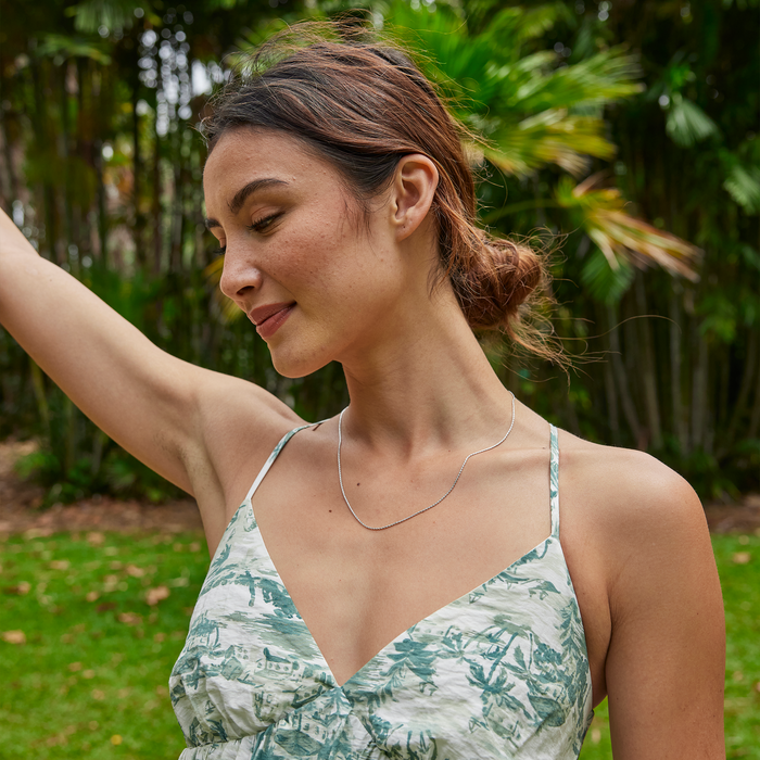 Woman in a garden wearing 1.0mm Espiga Chain in Sterling Silver