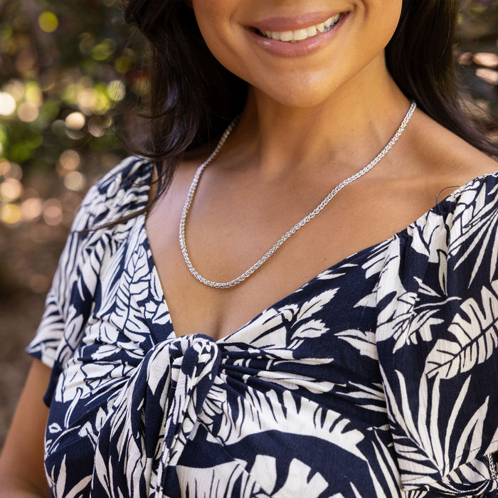 A womanʻs chest wearing a 2.5mm Espiga Chain in Sterling Silver