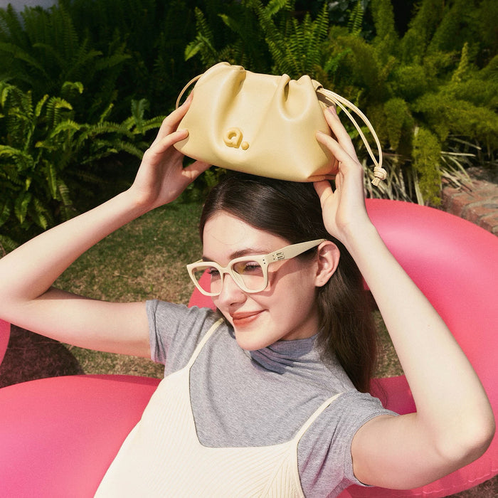Model holding a cream  yellow bag over her head, easy for commuting and weekends.
