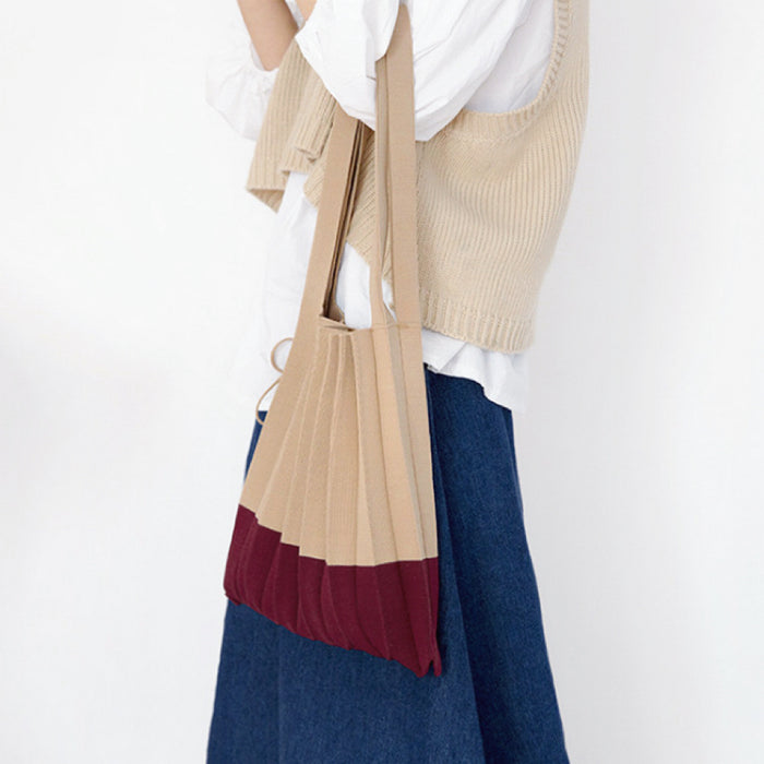 Model carrying a khaki and burgundy Accordion Foldable Knitted Bag handheld, easy for commuting and weekends.
