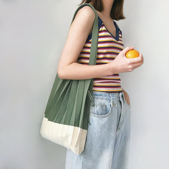 Model carrying a forest green Accordion Foldable Knitted Bag on shoulder , great for daily carry and travel.