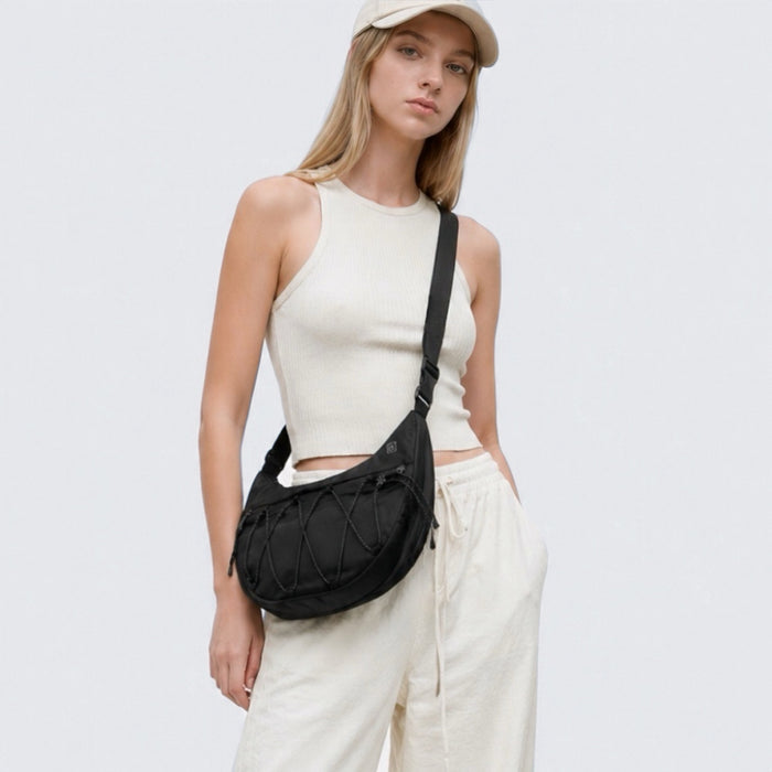 Model wearing a black lightweight nylon crescent sling bag as crossbody, showcasing the effortless urban style.
