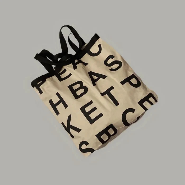 Flat lay of khaki Alphabet Canvas Tote Bag With Double Strap, easy for commuting and weekends.
