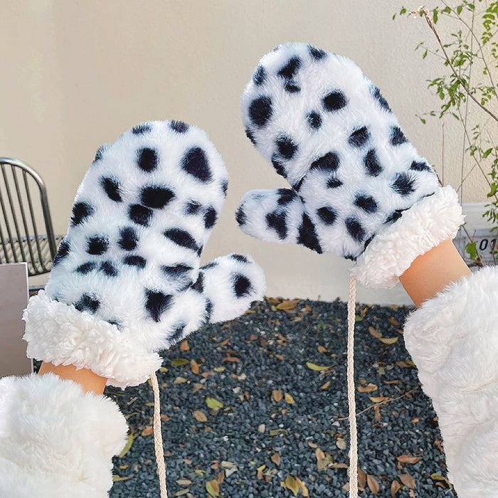 Cow print fluffy gloves with plush texture, flat lay; playful warm gloves for chilly weather.