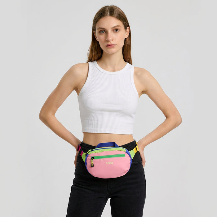 Close-up of a pink AOIO belt bag worn as a front waist bag.