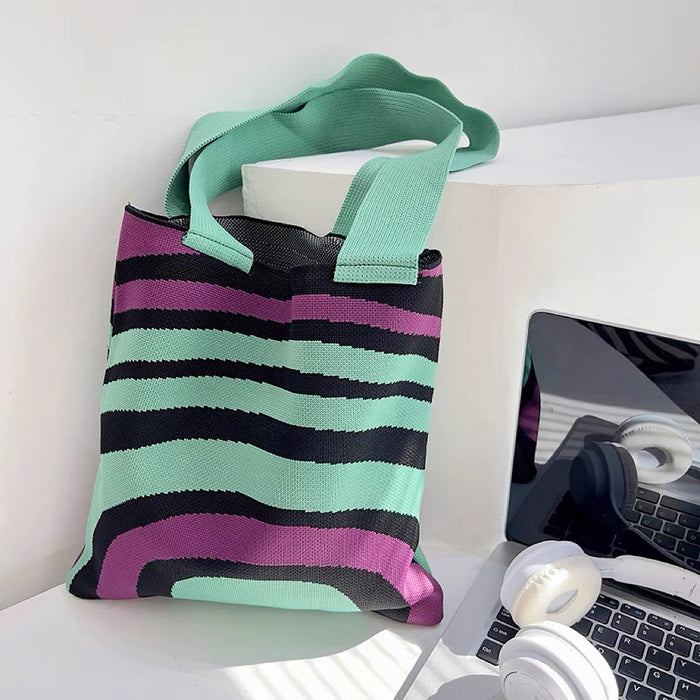Close-up of  Arc Line Knitted Bag in green and purple, ideal for errands and gifting.