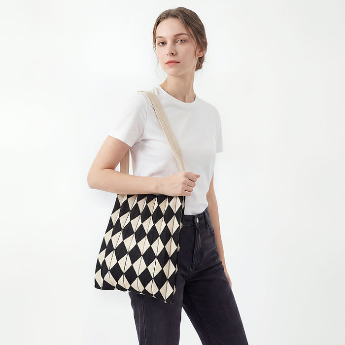 Model styling a black and beige argyle pleated knit bag for a minimalist  style