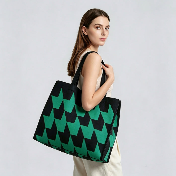 Model carrying a green arrow print tote bag on shoulder, showcasing the bold geometric style and large capacity.
