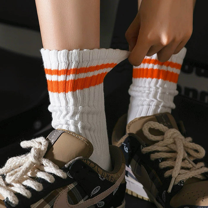 Model wearing a pair of orange Athletic Striped Slouch Socks , great for casual wear and light workouts.
