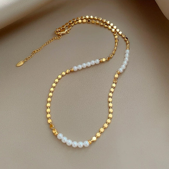 Flat lay of gold link necklace with white imitation pearls, refined aesthetic accessory