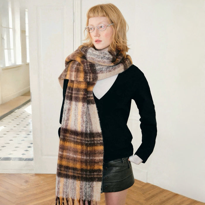 Model wearing Autumn Ember Plaid Scarf, a wool blend, fringed scarf with brown, orange, and cream checks.