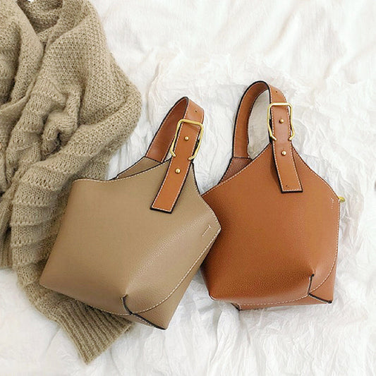Front view of Two Balloon Bucket Bags: one khaki, one tan, with asymmetric design.