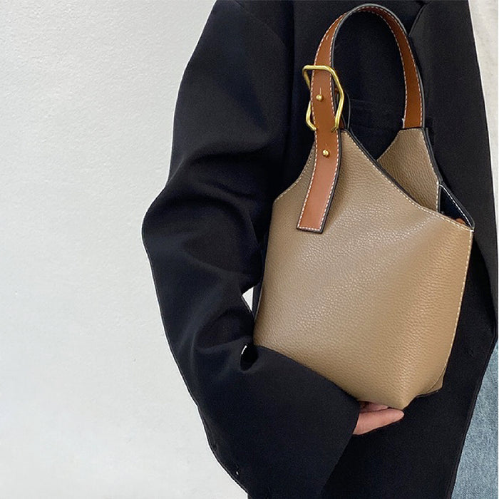 Model carrying a khaki balloon bucket bag handheld, easy for commuting and weekends.