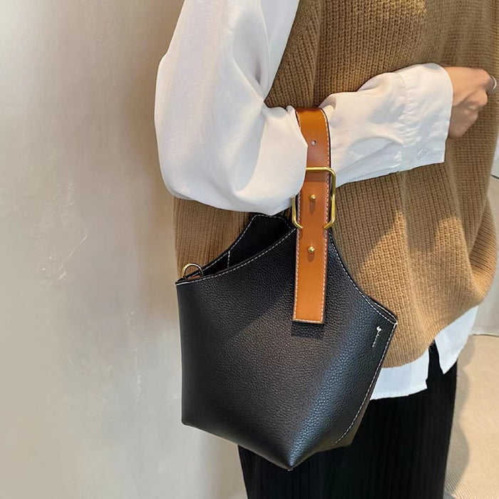 Model carrying a black  Balloon Bucket Bag handheld, great for daily carry and travel.