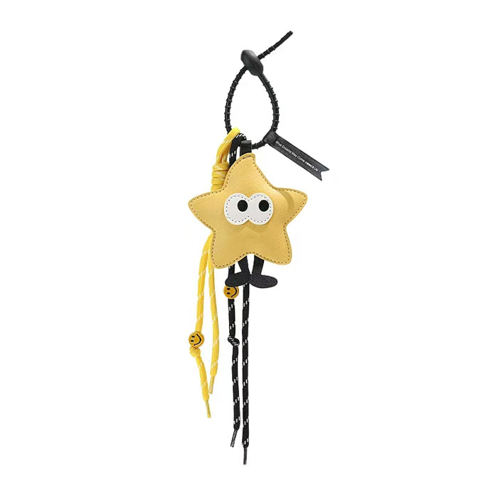 Front view of Yellow polyester star bag charm with big eyes, black legs, and yellow braided cord with smiley beads.