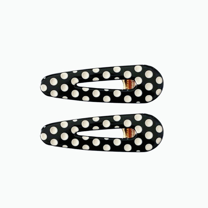 Angled view of Black And White Dot Hair Clips in arrow shape, ideal for quick updos and ponytails.