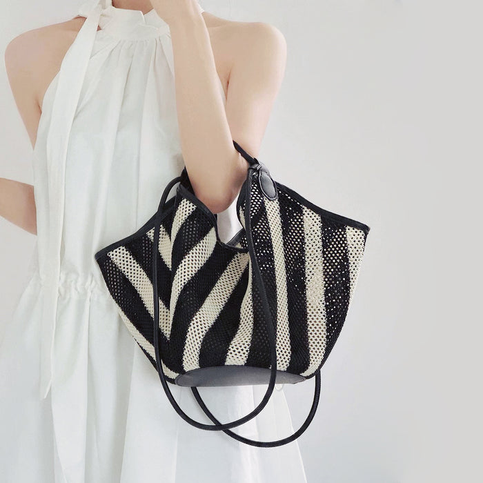 Model carrying a Black and white striped basket bag handheld, great for daily carry and travel.