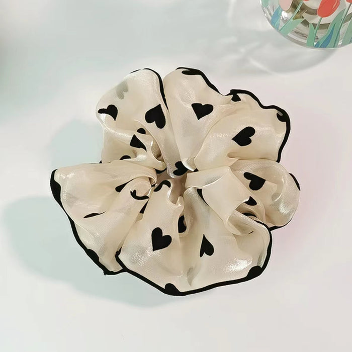 Angled view of Black Trim Satin Scrunchie, ideal for quick updos and ponytails.