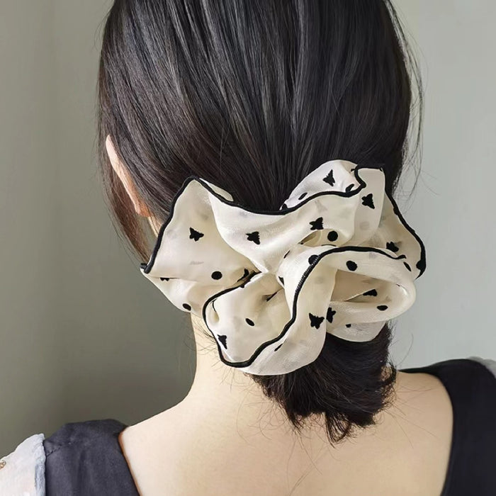Model wearing Black Trim Satin Scrunchie with butterfly pattern, easy for workdays and special occasions.
