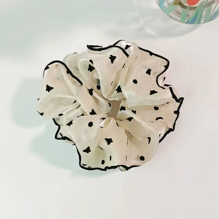 Flat lay of Black Trim Satin Scrunchie with butterfly pattern, great for everyday styling and gifting.