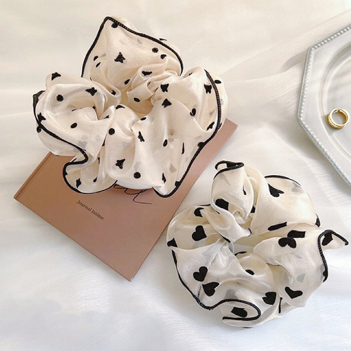Two Black Trim Satin Scrunchies with heart pattern and butterfly pattern, ideal for quick updos and ponytails.