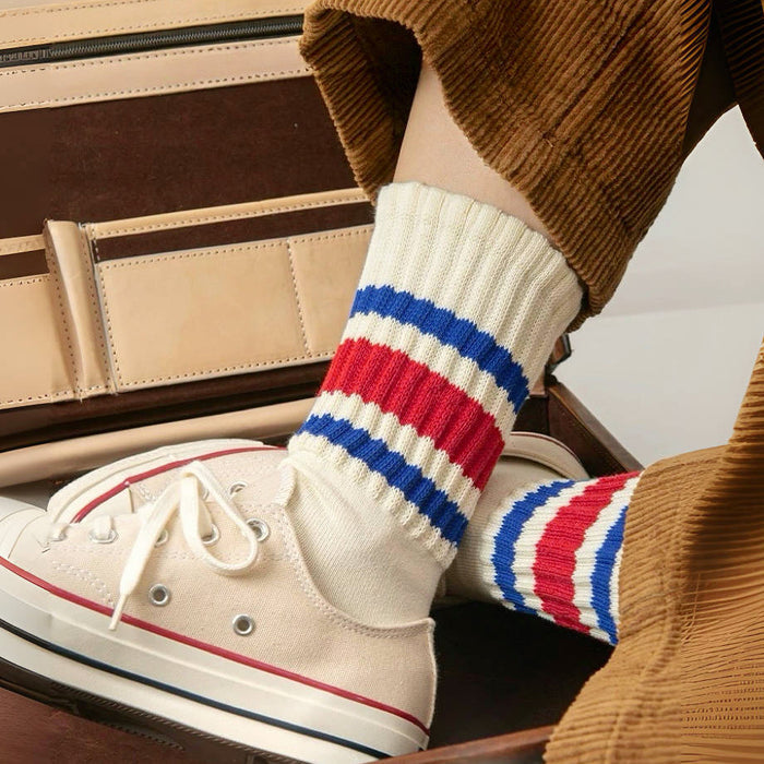 Model wearing a pair of blockcore slouch socks in blue and red, easy to pack for travel and errands.