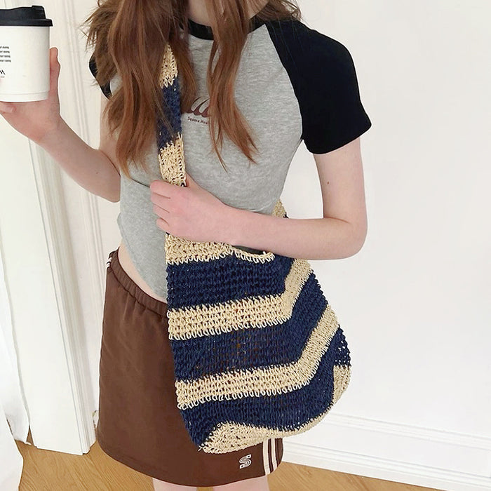 Model carrying a blue striped tote bag  as crossbody, easy for commuting and weekends.