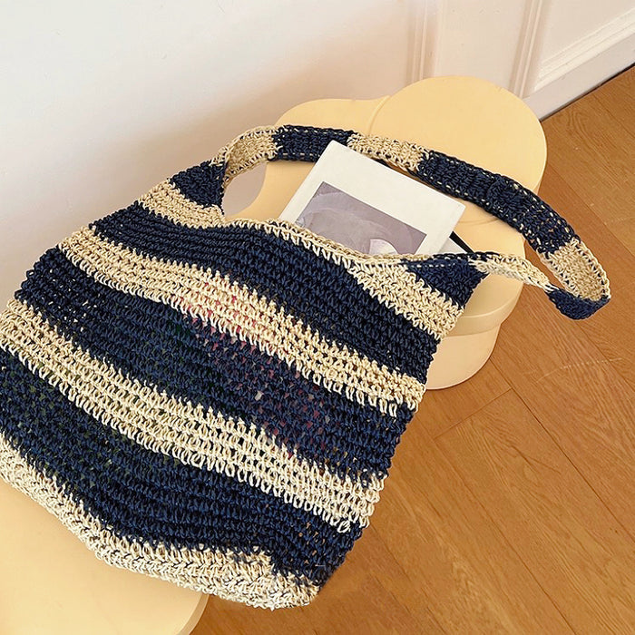 Flat lay of Crochet Straw Tote Bag In Blue Stripe, great for everyday carry and travel.