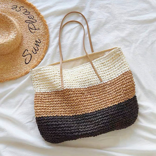 Front view of Bohemia straw tote bag with white, brown, and black horizontal stripes, and tan PU leather straps.