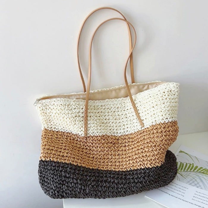 Angled view of Bohemia straw tote bag with horizontal stripes.