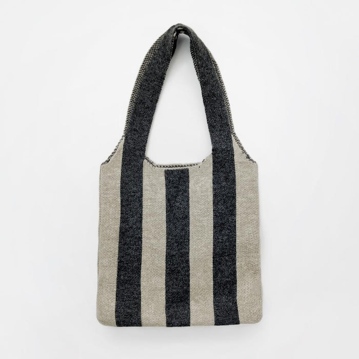 Close-up of Wool blend knit bag with bold black and beige vertical stripes and a shoulder strap wool shoulder bag.