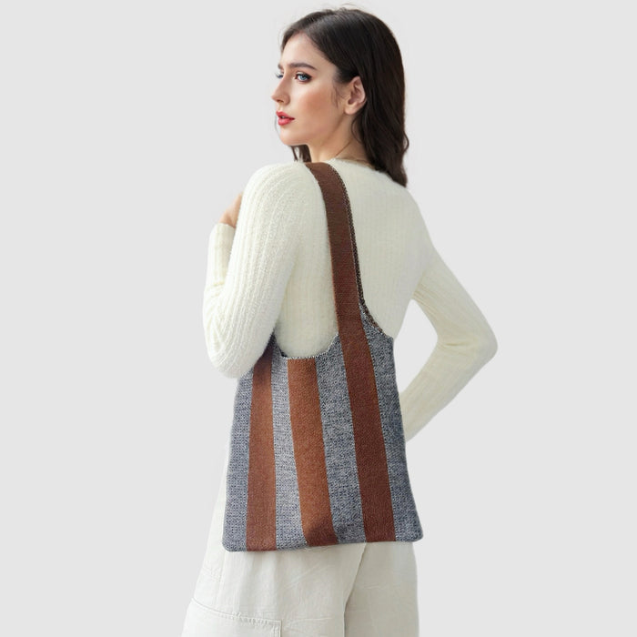 Model carrying a wool bag on the shoulder Bold Band Knit Bag in ocher, ideal for city walks and gifting.