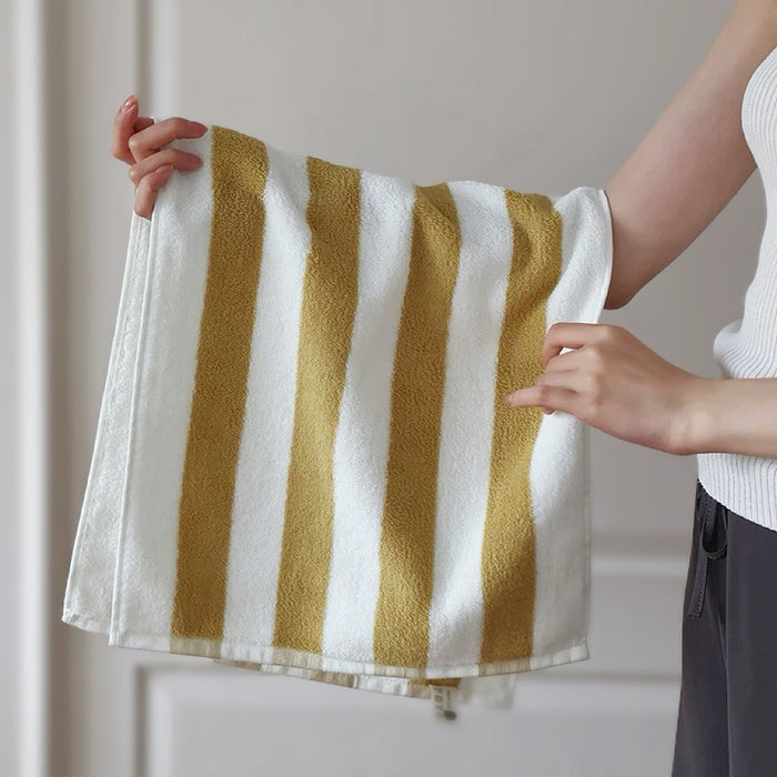 Model holding a Bold Color Striped Face Towel in white-mustard, easy for gym, travel, and weekends.