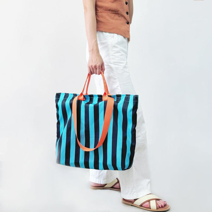 Model carrying a Bold Color Striped Tote Bag in blue, ideal for city walks and gifting.