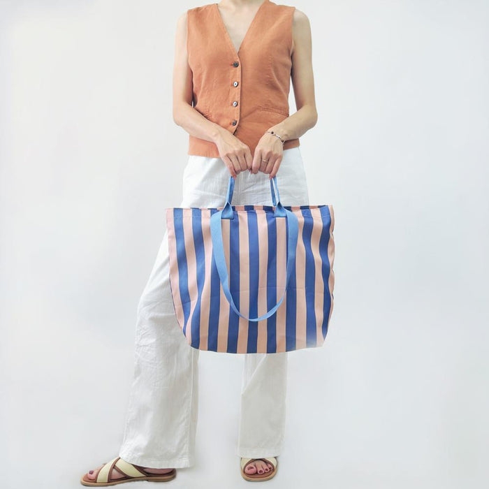 Model carrying a violet Bold Color Striped Tote Bag handheld, great for daily carry and travel.
