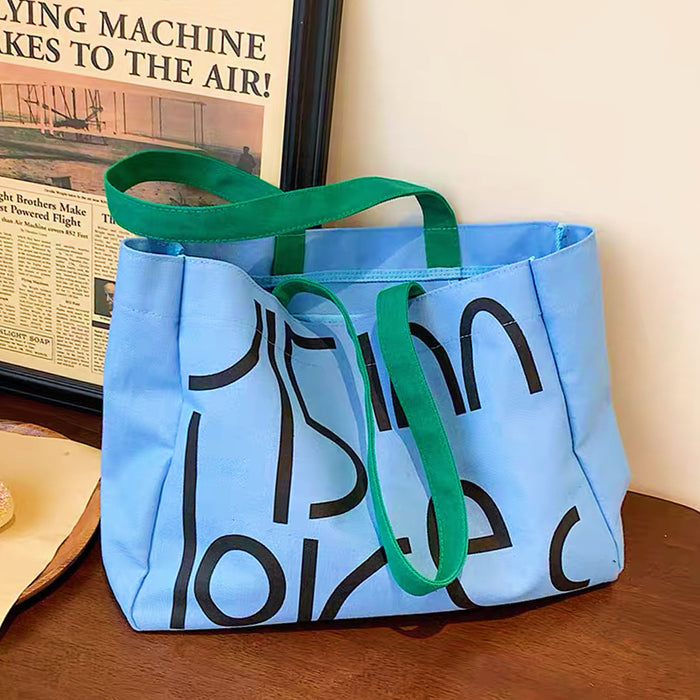 Front view of the blue canvas tote bag with black typography; minimalist scandi-style accessory.